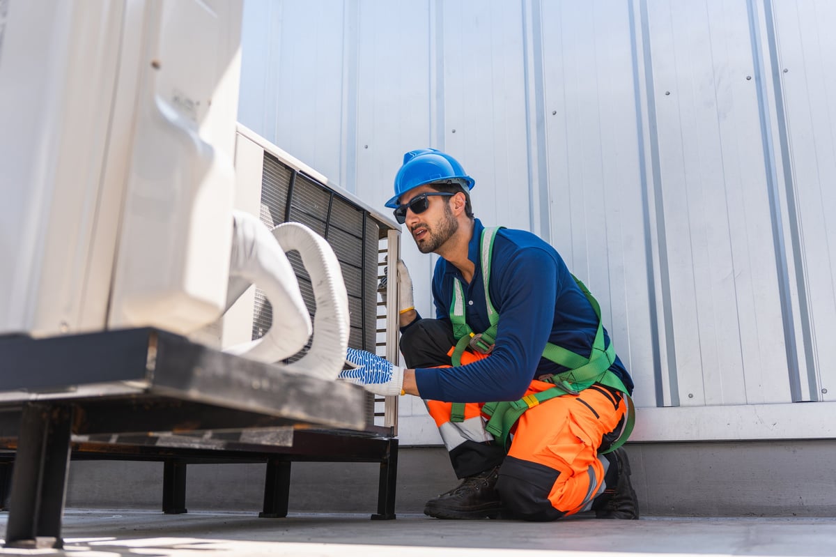 Professional HVAC technician performing maintenance on air conditioning system with precision and expertise